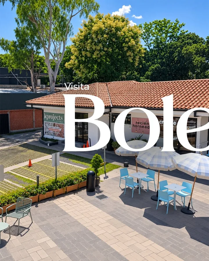 Patio de Bolengo Plaza con mesas, sombrillas y tejados; primera mitad de la composición «Visita Bolengo Plaza».