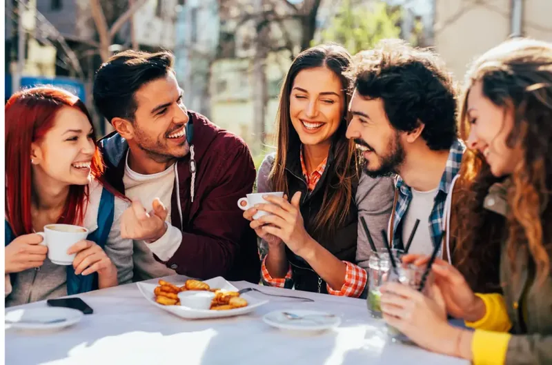 Fotografía editorial de amigos conversando y compartiendo una mesa